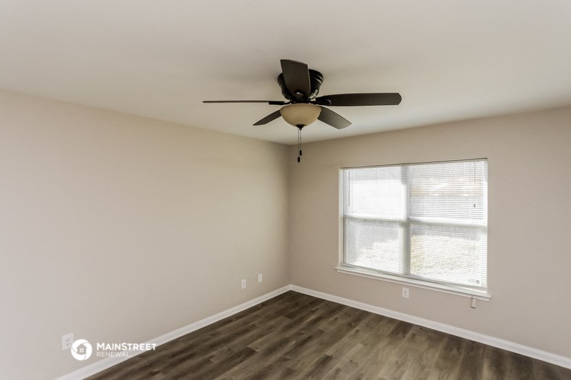 a bedroom with a ceiling fan and a window
