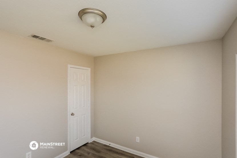 a bedroom with a white door and a ceiling fan