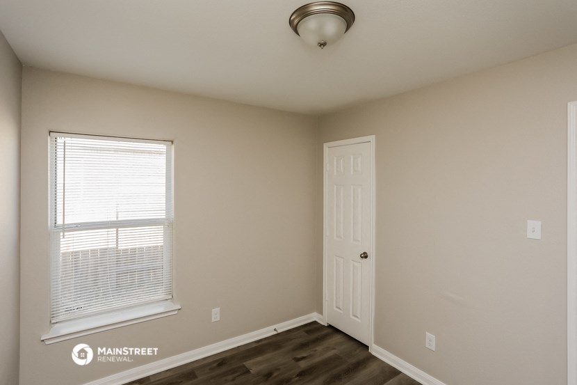 the interior of a bedroom with a door and a window