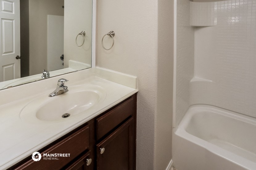 a bathroom with a sink and a tub and a mirror