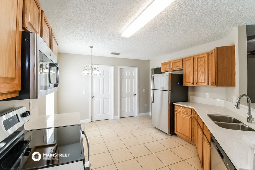 a kitchen with wooden cabinets and stainless steel appliances