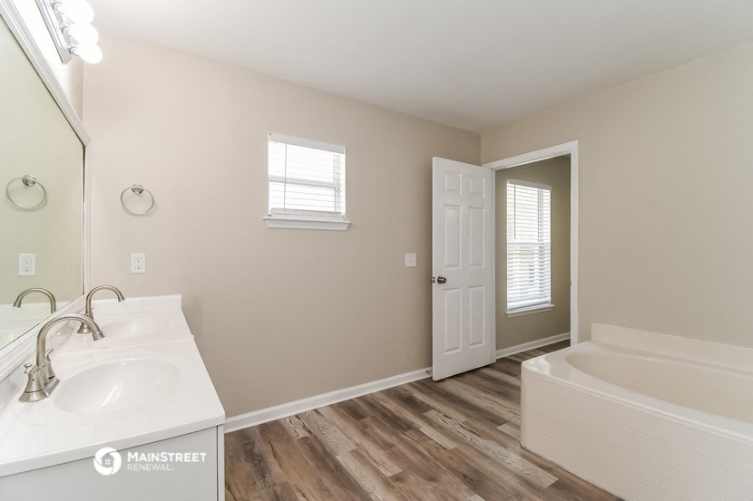 a bathroom with a tub and a sink and a mirror
