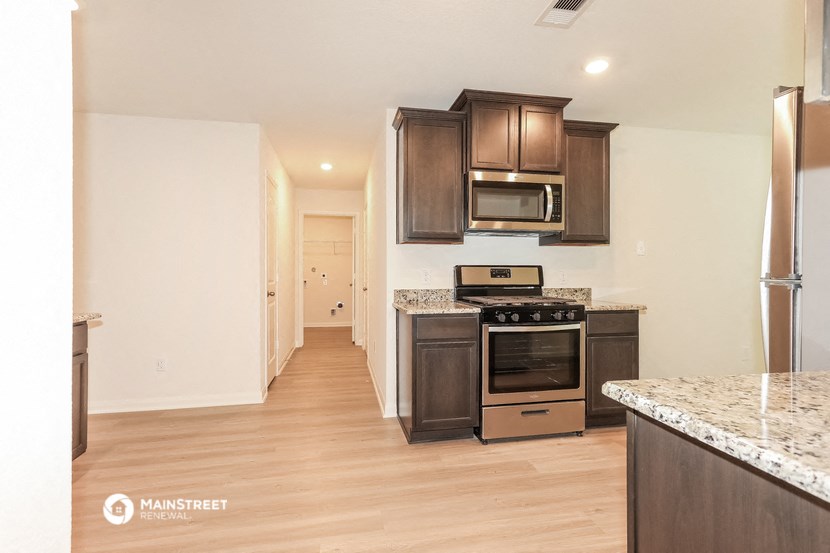 a kitchen with wooden cabinets and stainless steel appliances and marble counter tops
