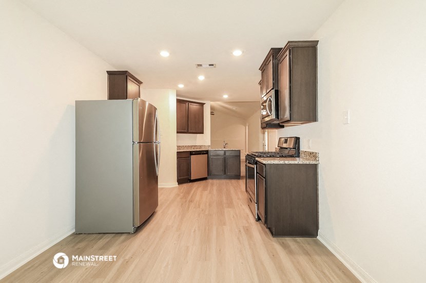 a renovated kitchen with stainless steel appliances and wood flooring