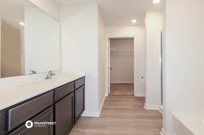 a bathroom with a sink and a hallway to a closet
