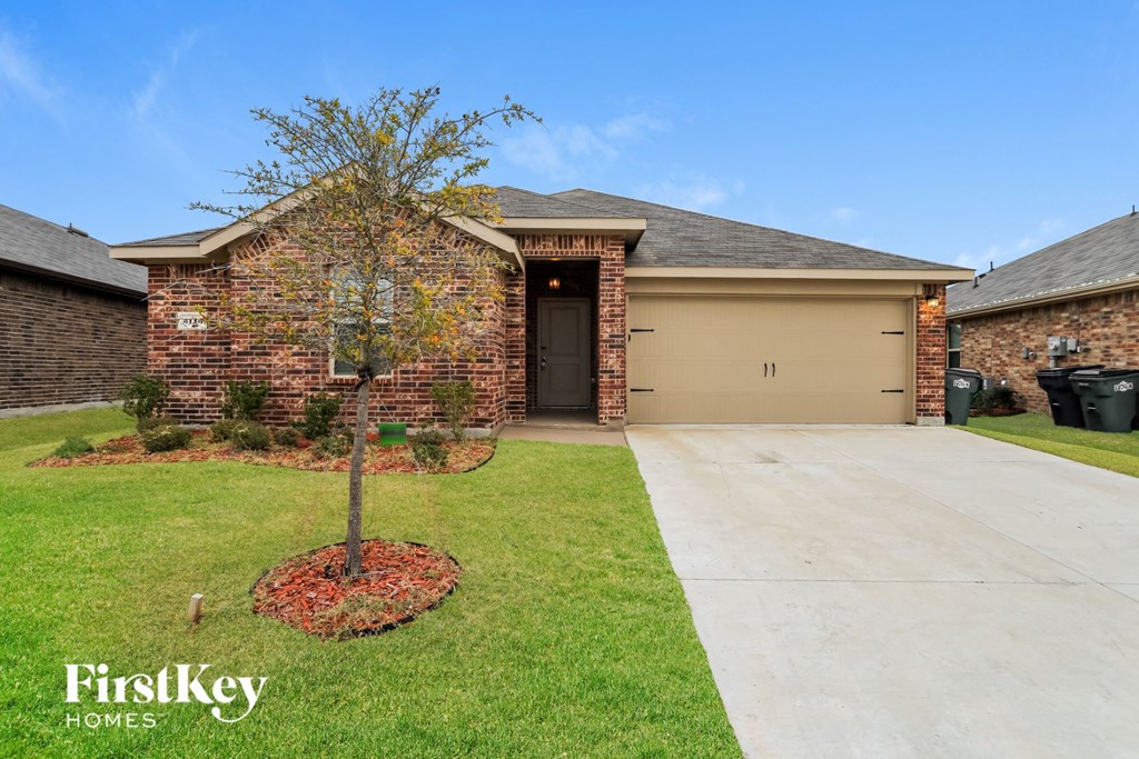 A brick house with a tree in front of it.