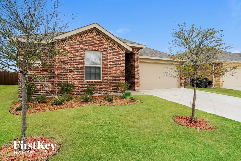 A brick house with a tree in front of it.