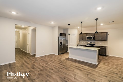 A kitchen with a refrigerator, microwave, and oven is shown in a FirstKey Homes advertisement.