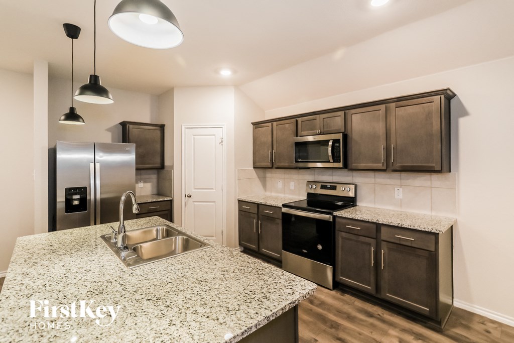 A kitchen with granite countertops and stainless steel appliances.