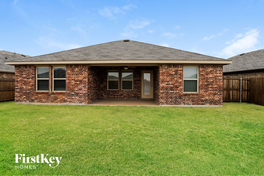 A brick house with a green lawn in front.