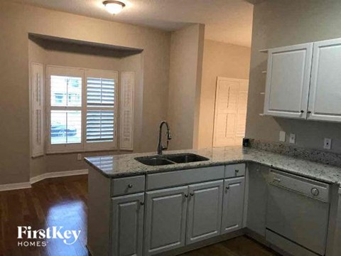 a kitchen with white cabinets and a sink