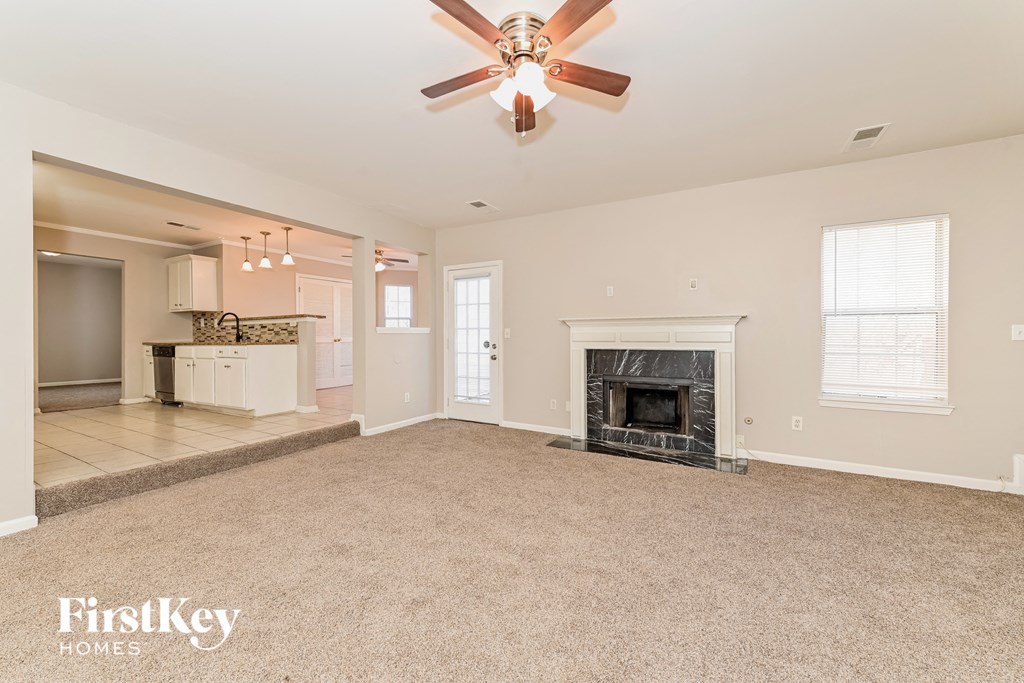 a living room with a fireplace and a ceiling fan