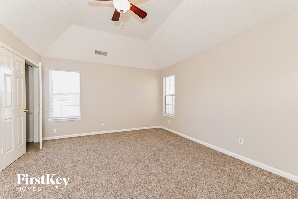 a bedroom with carpet and a ceiling fan