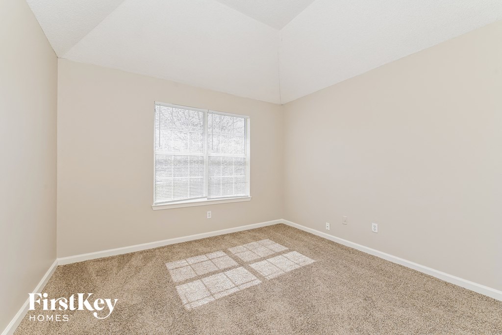 a bedroom with carpet and a window