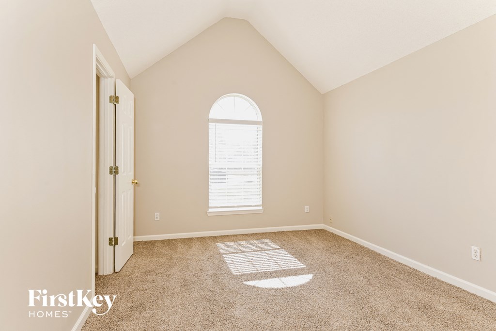 an empty room with carpet and a large window