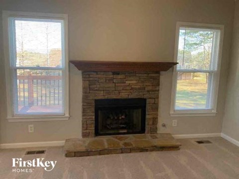 a living room with a fireplace and two windows