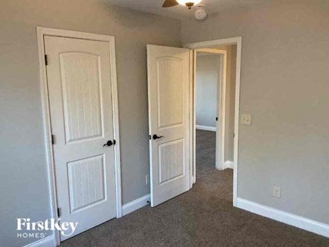 a bedroom with three doors and a carpeted floor