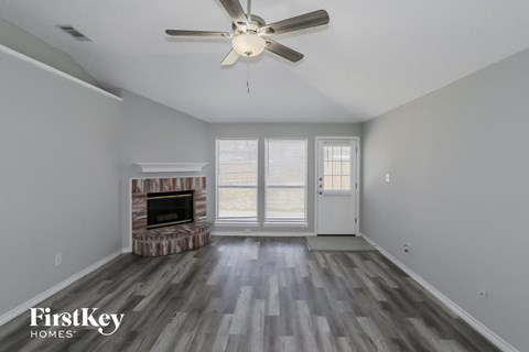 a living room with a fireplace and a ceiling fan