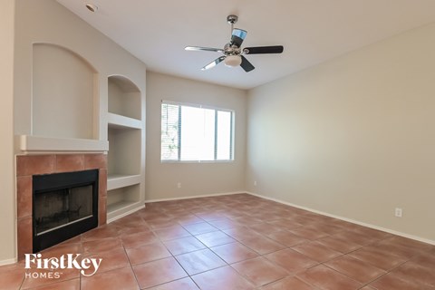 a living room with a fireplace and a ceiling fan