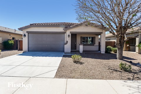 a home with a tree and a driveway in front of it