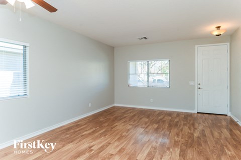 the living room of a home with wood floors and a white door