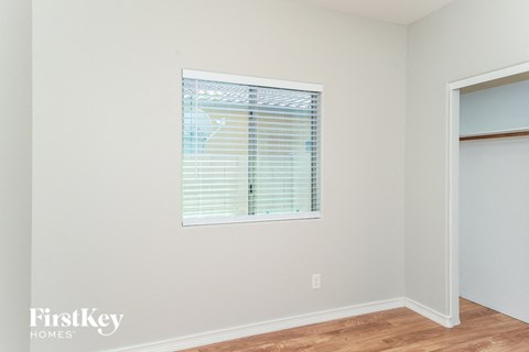 a bedroom with a window and a door to a closet