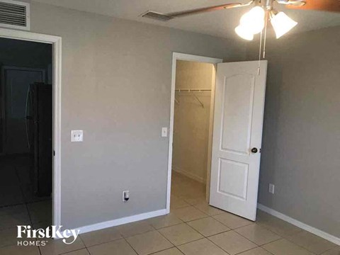 an empty living room with a closet and a white door
