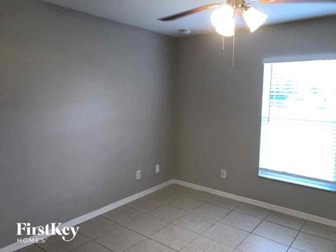 a empty room with a ceiling fan and a window