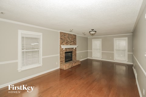 the living room of a house with a fireplace and wooden floors