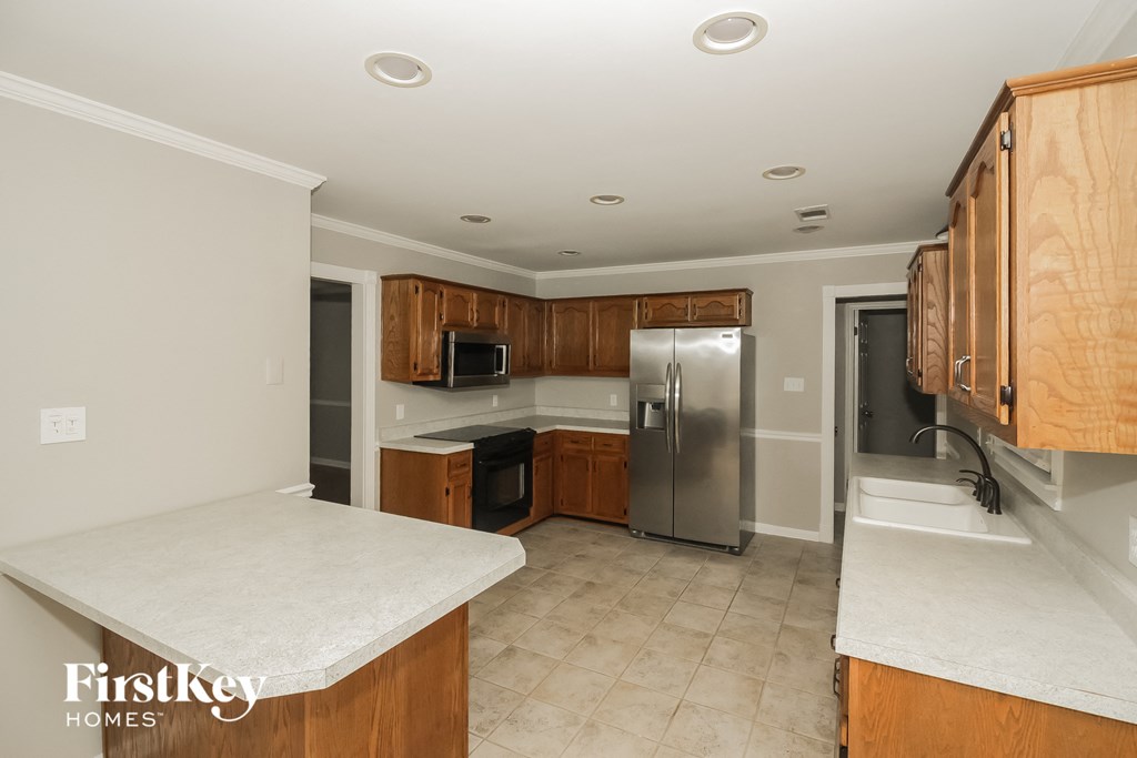 a kitchen with wooden cabinets and a stainless steel refrigerator