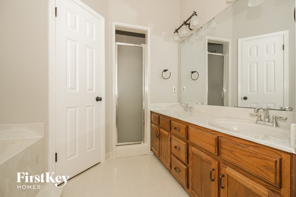 a bathroom with wooden cabinets and a sink and a mirror