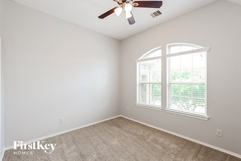 a bedroom with a ceiling fan and a window