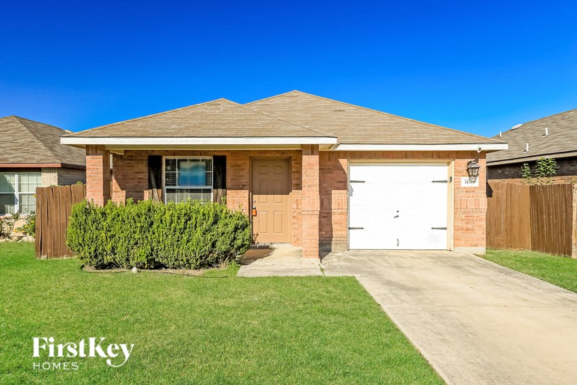 a small brick house with a white garage door