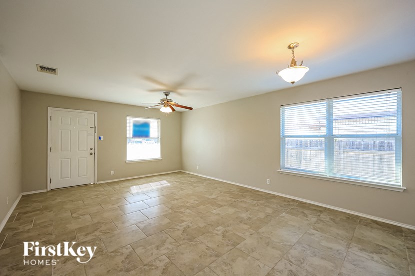 a living room with a ceiling fan and a large window