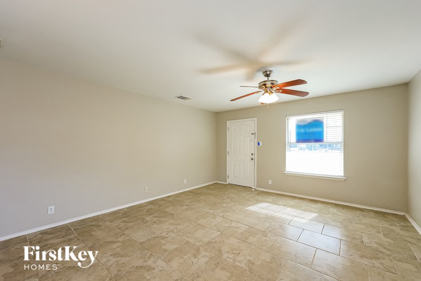 a clean and empty living room with a ceiling fan