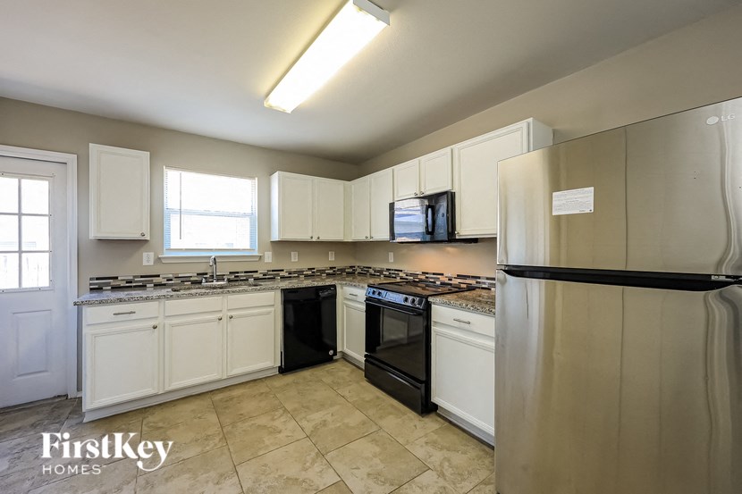 a kitchen with stainless steel appliances and white cabinets