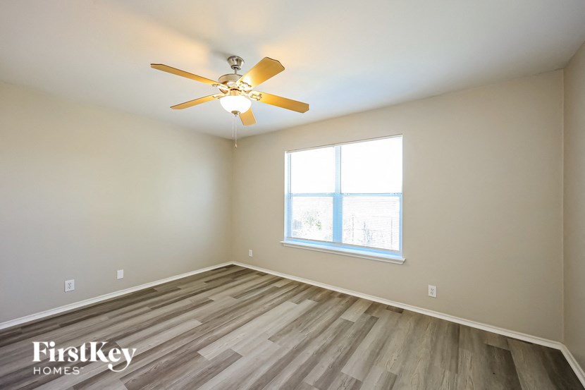 a bedroom with a ceiling fan and a window