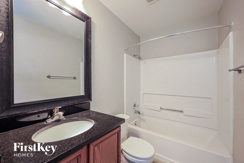 a bathroom with a sink and a toilet next to a shower and a bath tub