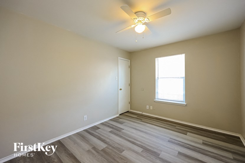 a bedroom with a ceiling fan and a window