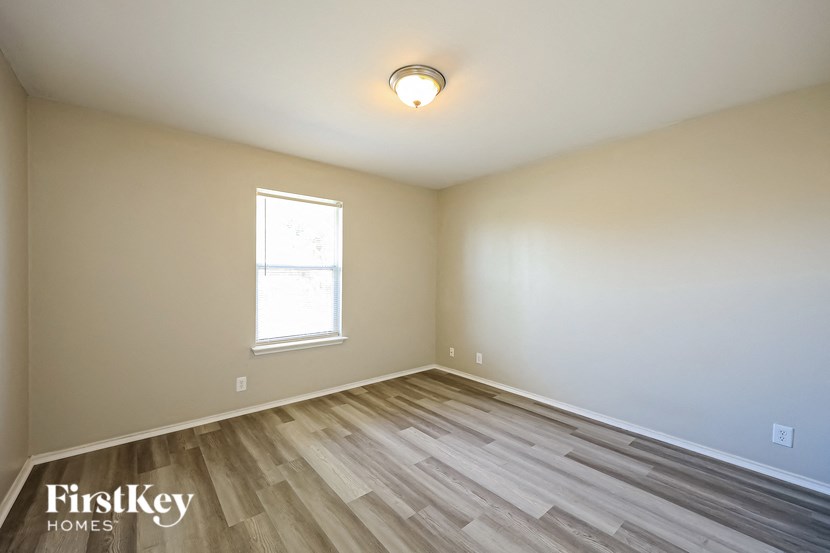 the second bedroom with wood flooring and a window