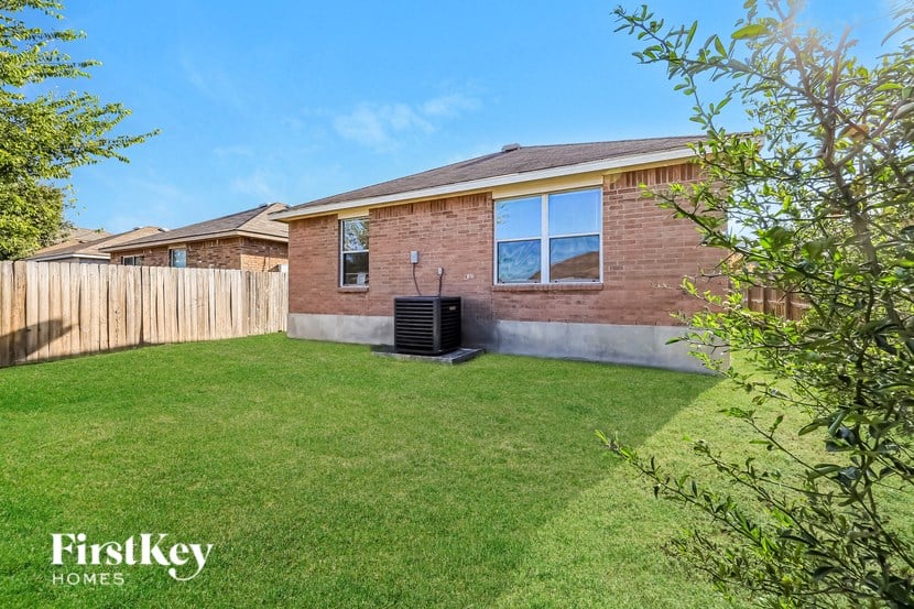 a backyard with a fence and a brick house