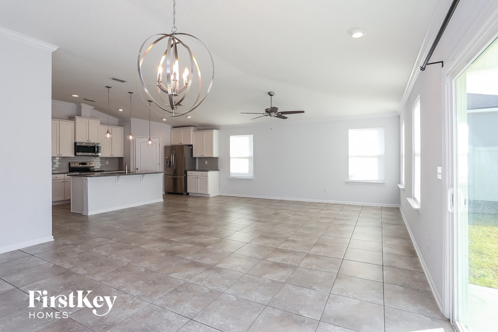 an empty kitchen and living room with a ceiling fan