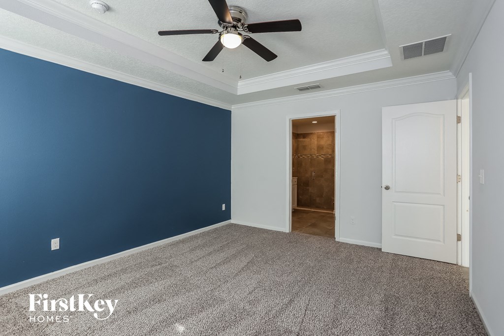 a bedroom with a blue wall and a ceiling fan