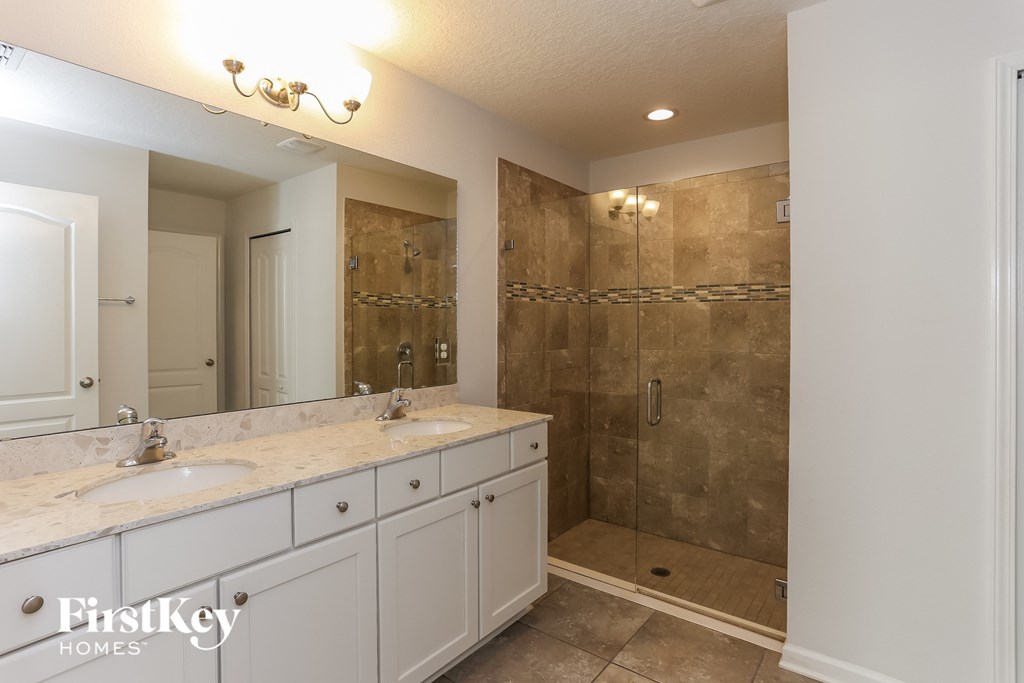 a bathroom with two sinks and a large shower