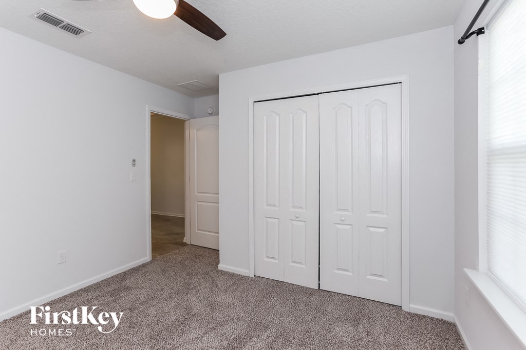 a bedroom with two closets and a carpeted floor