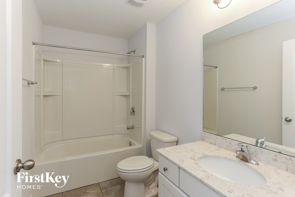 a white bathroom with a shower toilet and sink
