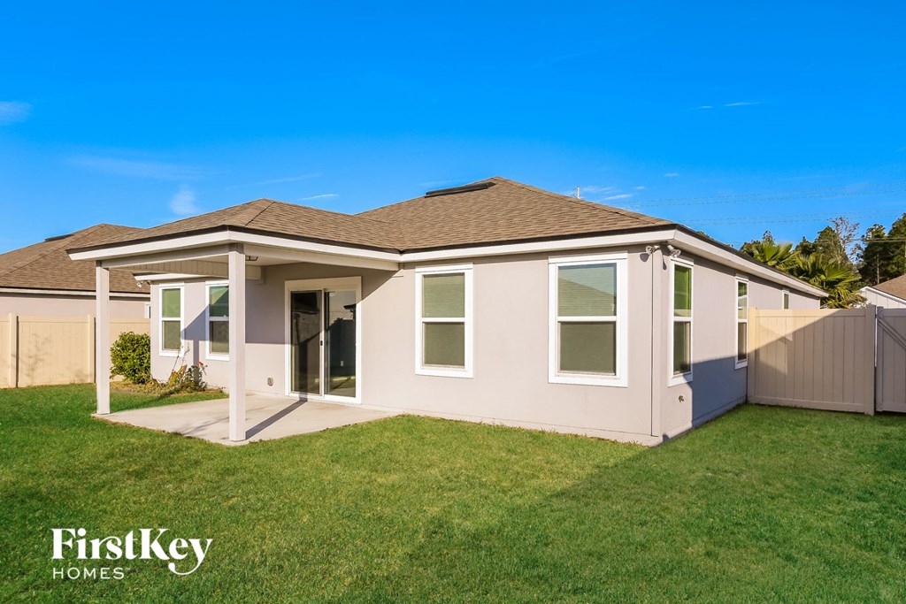 a beige house with a lawn and a blue sky