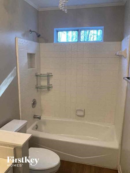 a white bathroom with a tub and a toilet