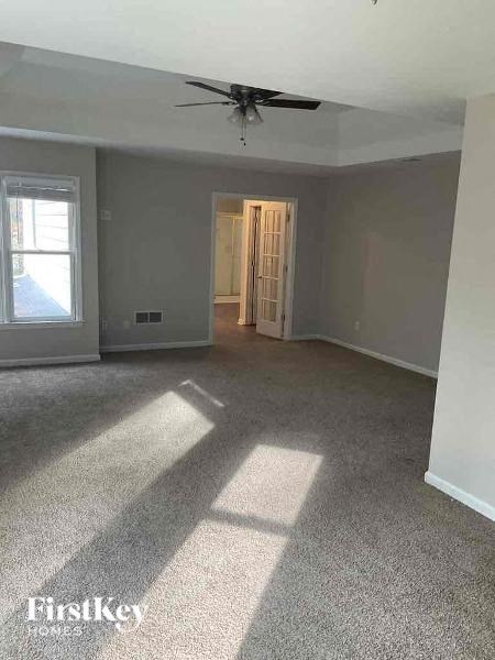 an empty living room with a ceiling fan