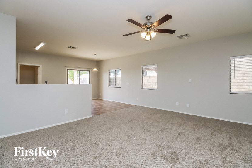 an empty living room with a ceiling fan